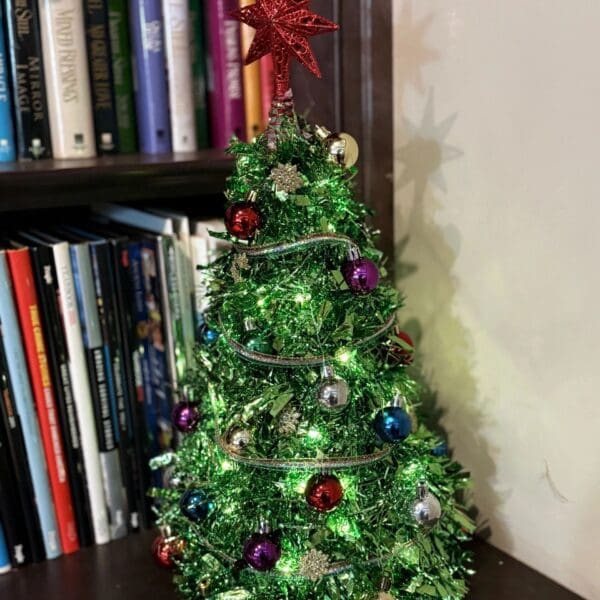 Festive tree on bookshelf corner