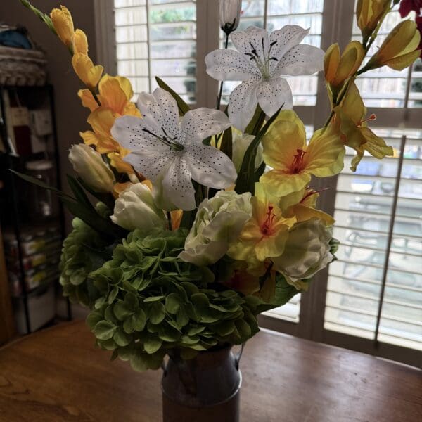 A vibrant bouquet of mixed flowers in a vase near a window.