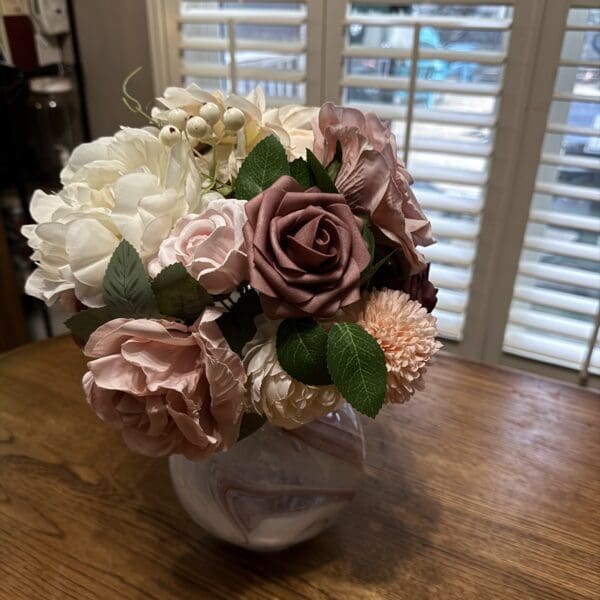 Elegant bouquet of white and pink roses in a classic vase.