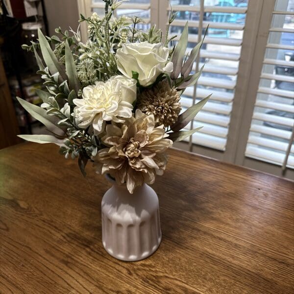 Elegant white floral arrangement in a ribbed ceramic vase.