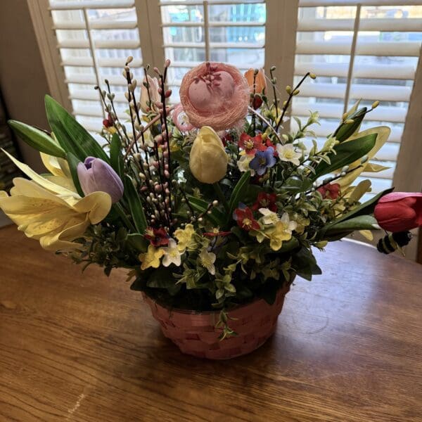 Colorful flower arrangement in a pink basket.