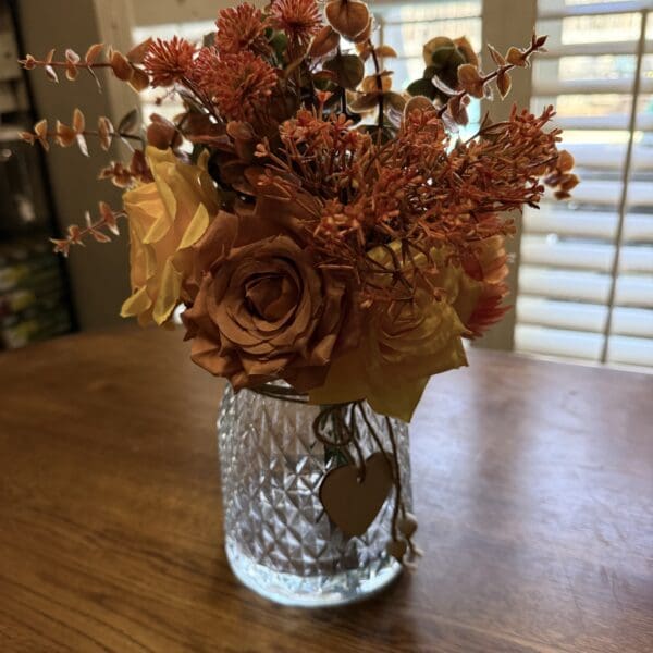 Orange and yellow flowers in glass vase.