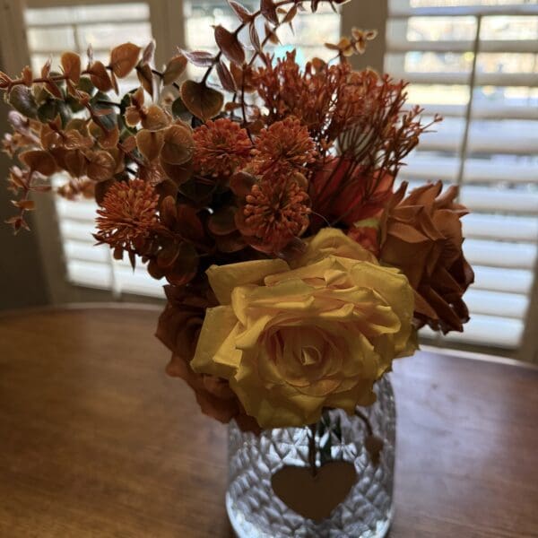 Yellow and orange flowers in glass vase.