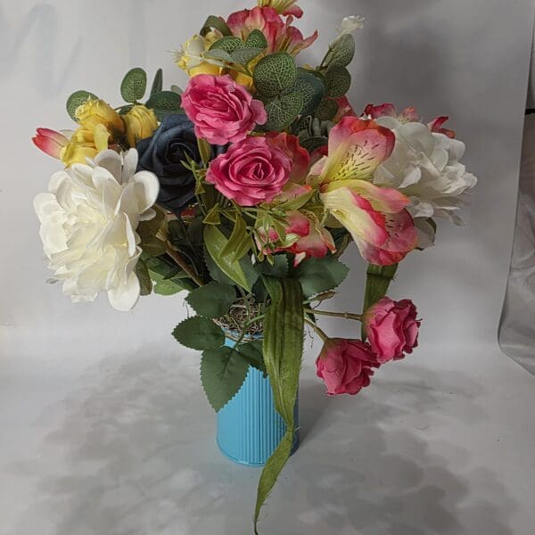 Bouquet of colorful flowers in blue vase.