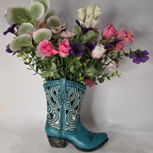 Floral arrangement in decorative blue boot vase.