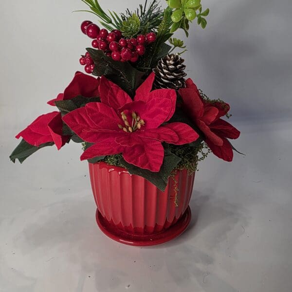 Red poinsettia arrangement in a red pot.