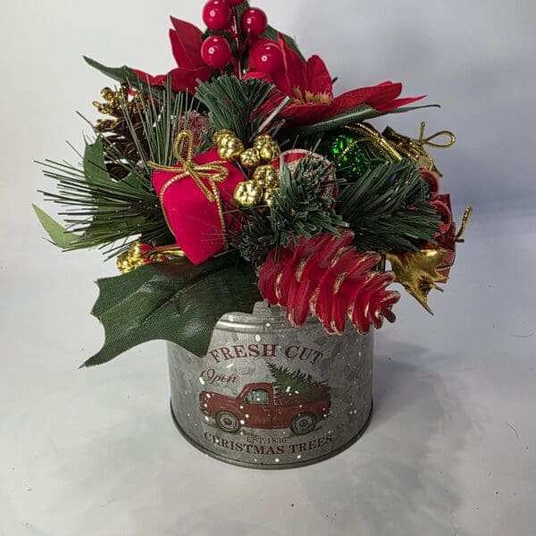 Festive floral arrangement in Christmas-themed container.