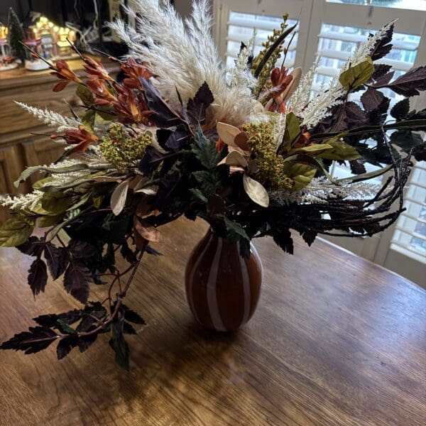 Autumn floral arrangement in a brown vase.