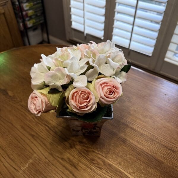 Bouquet of pink roses on wooden table.