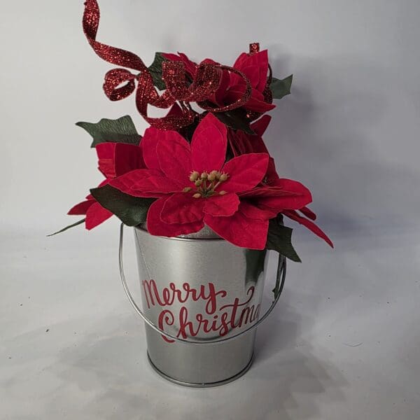 Festive bucket with poinsettias and ribbon.