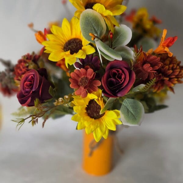 Bouquet of sunflowers and roses in vase.