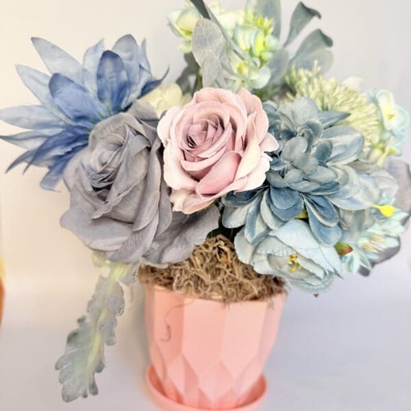 Bouquet of pastel flowers in pink pot.