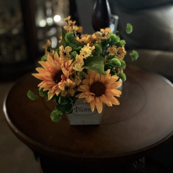 Sunflower arrangement on round wooden table.