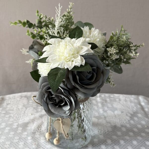 White and gray floral arrangement in glass jar
