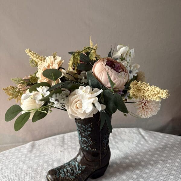 Floral bouquet arranged in decorative cowboy boot