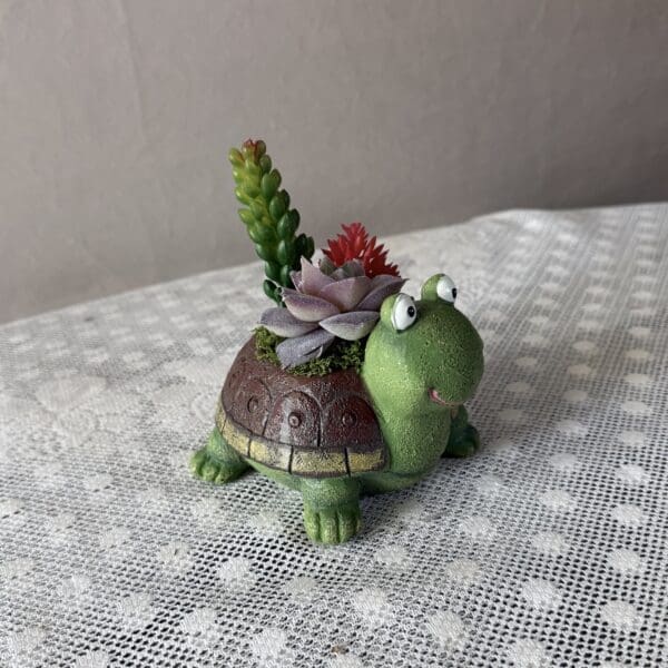 Turtle-shaped succulent planter on lace tablecloth