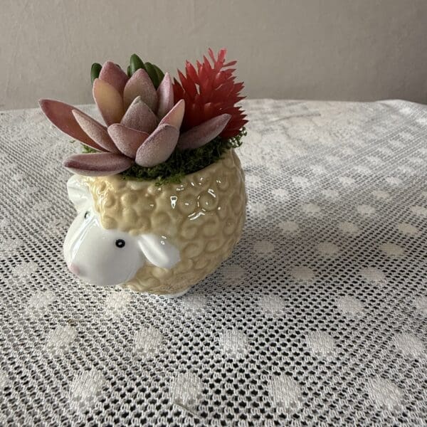 Sheep-shaped planter holding pink succulents
