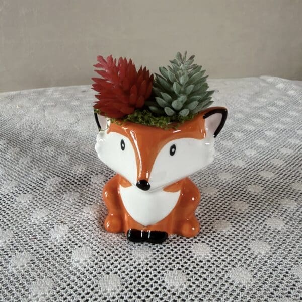 Ceramic fox planter holding succulents