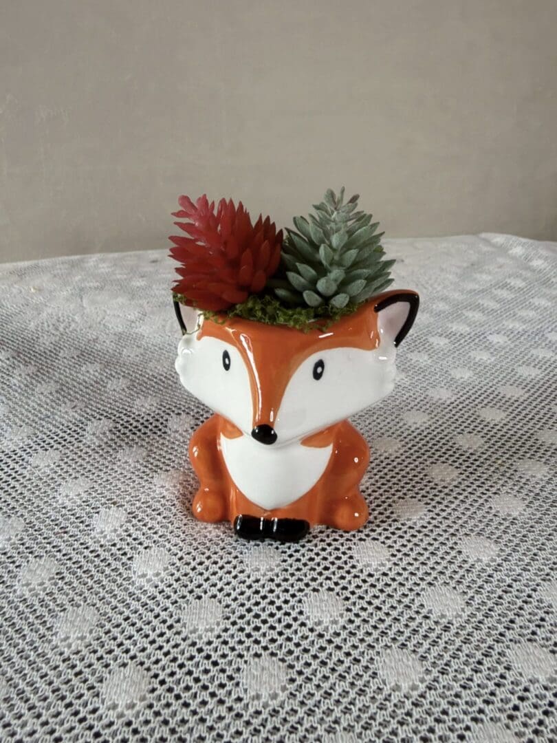 Ceramic fox planter holding succulents
